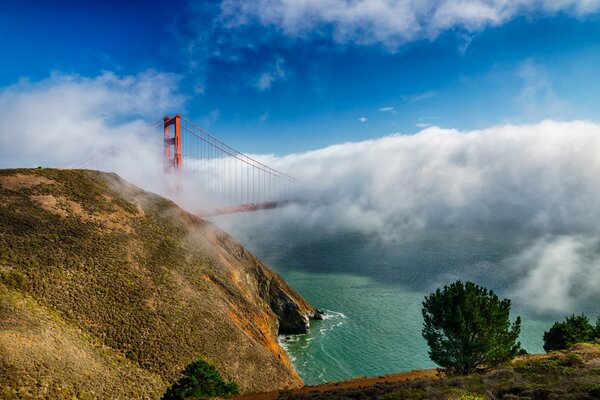 California bridge in fog against blue sky