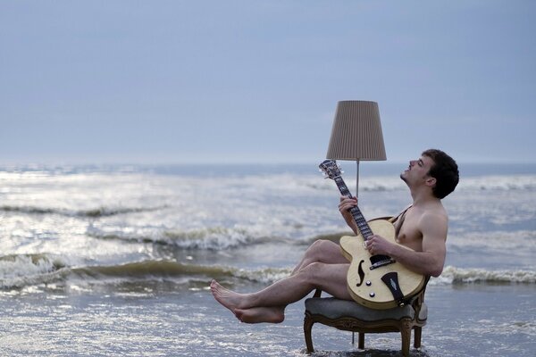 Homme avec une guitare au bord de la mer