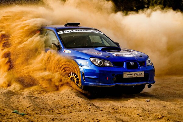 Blue Subaru Impreza on a sandy track