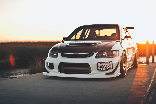 Mitsubishi Lancer en el puente a detrás de la puesta de sol