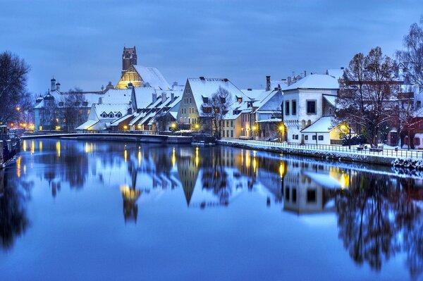 The winter village is reflected in the water