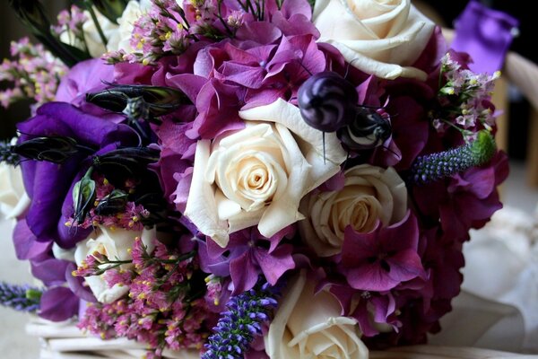 A delicate and bright bouquet of roses and purple hydrangea