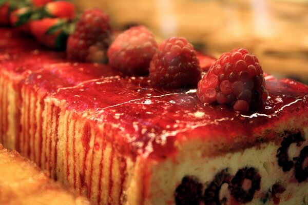 The cake with red syrup is decorated with fresh raspberries