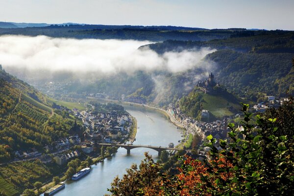 Blick auf die Stadt. Sommernebel und Wälder