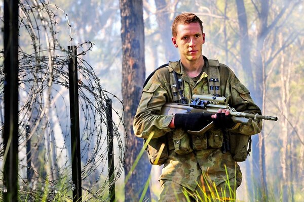 Stacheldraht hinter dem Rücken eines Soldaten