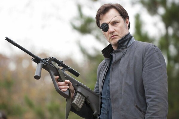 David Morrissey with a blindfold over one eye and a gun