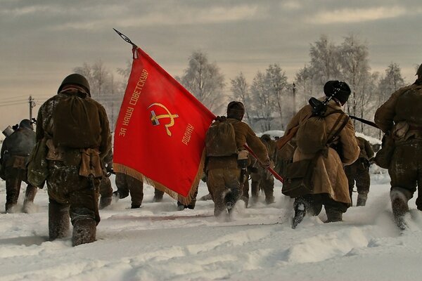 Stormtrooper soldiers walk through the snow, carrying the banner of the Soviet Union