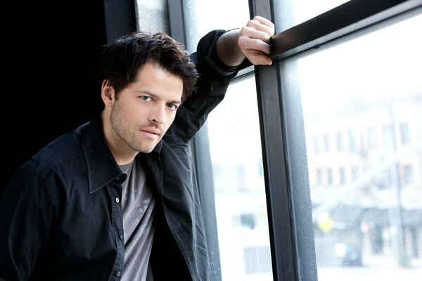 Attore Misha Collins vicino alla finestra