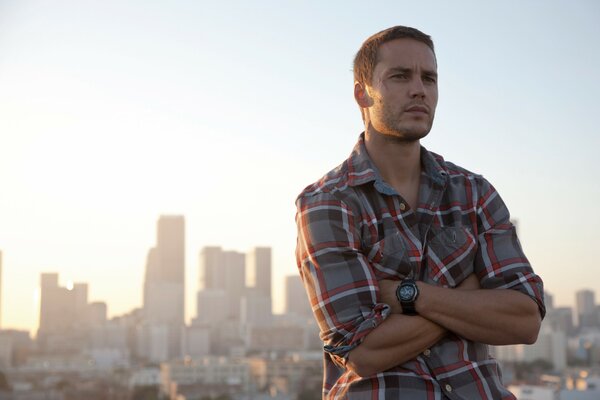 Taylor Kitsch on the background of the city