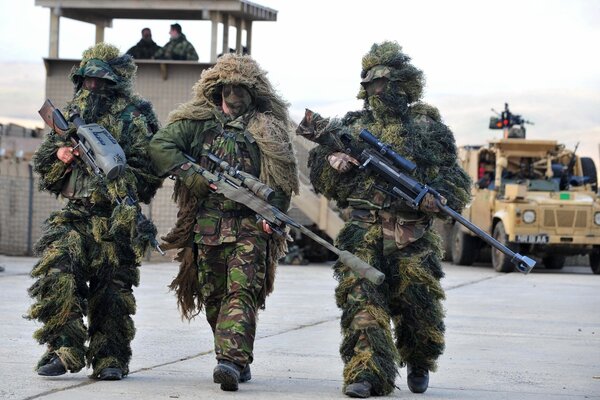 Tres soldados en camuflaje con armas en la mano