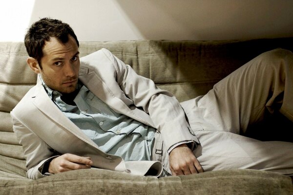 Jude Law posing on the couch