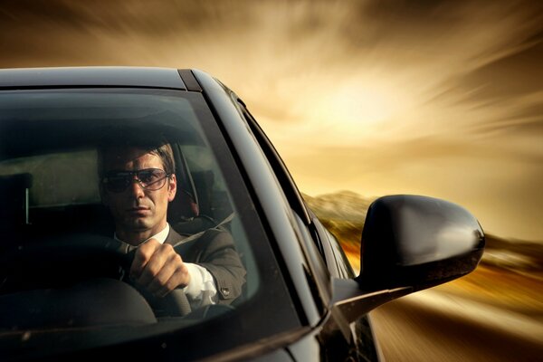 A man driving a black car