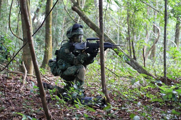 Soldat mit Waffen in der Natur