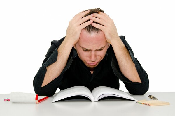 A desperate student is sitting at a textbook