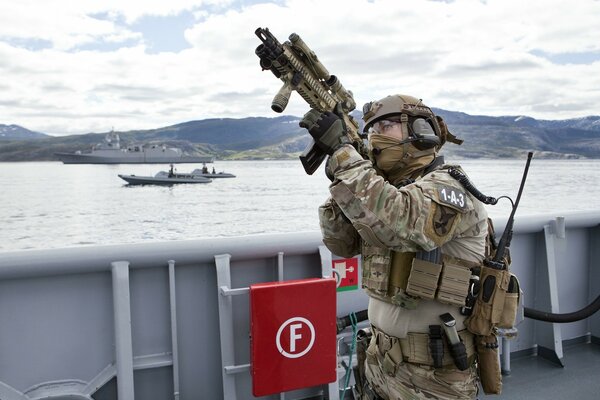 Soldat mit Waffen auf dem Hintergrund der Berge