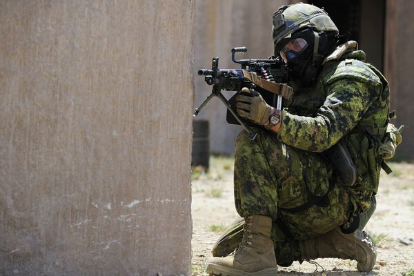 A soldier in camouflage and with a machine gun