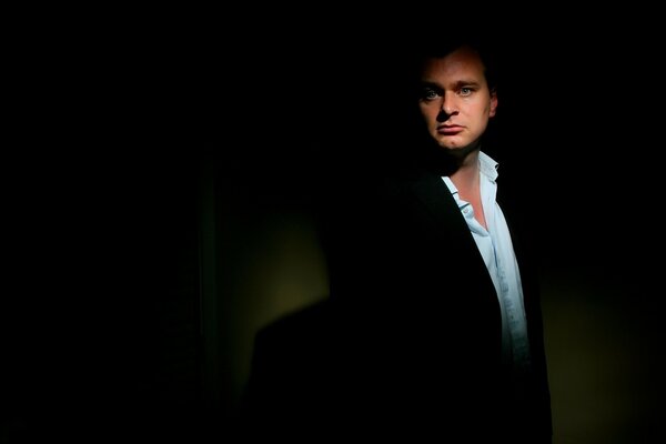 Director Christopher Nolan on a black background