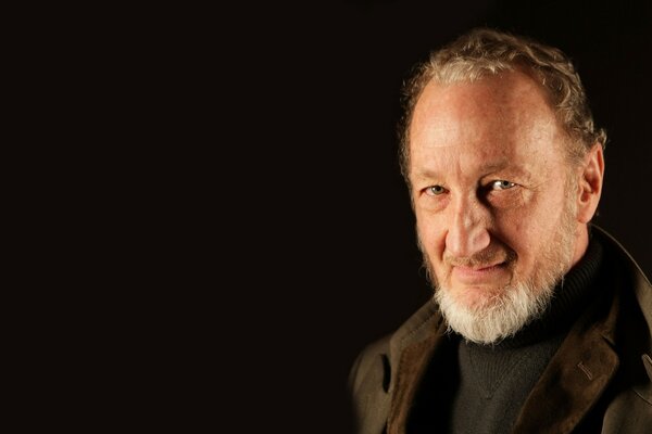 Portrait on a black background of actor Robert Englund