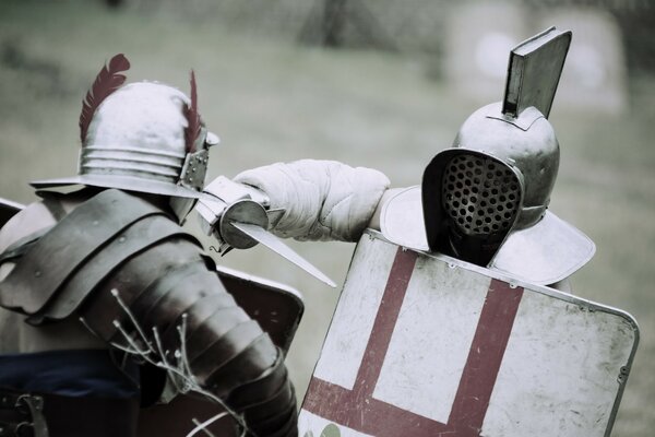 Battle of gladiators in armor with swords