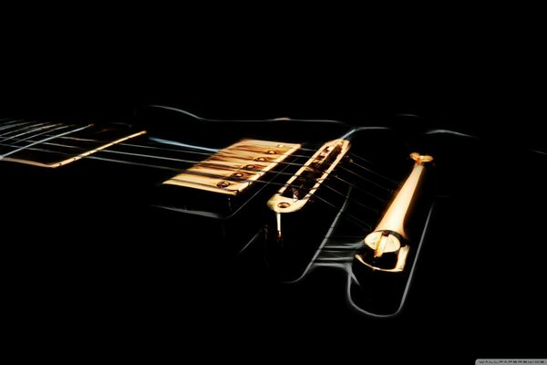 Black guitar with strings on a black background