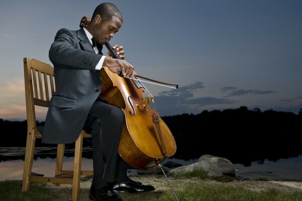 Sur le fond du ciel, un musicien est assis sur une chaise