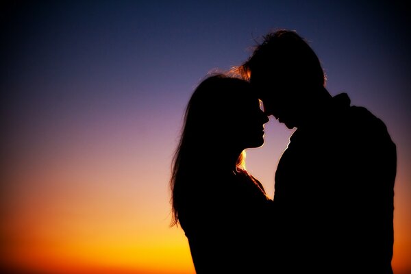 A happy couple in front of the evening sky