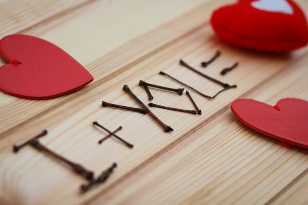 The inscription I+YOU = on a wooden background with hearts