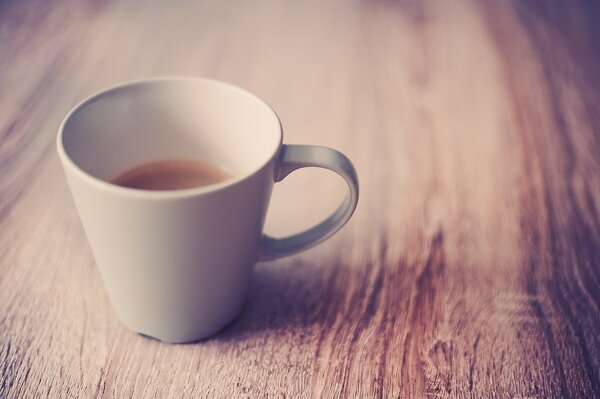 Coffee at the bottom of a cup on a wooden table