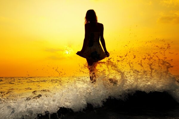 Jeune fille se trouve dans l eau et regarde le coucher du soleil