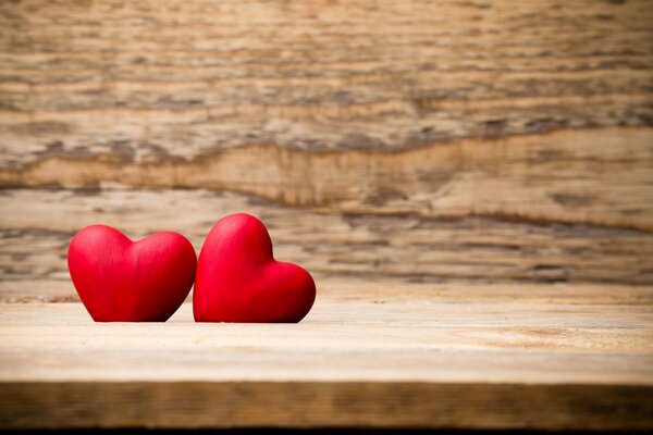Два красных сердца на деревянной подставке