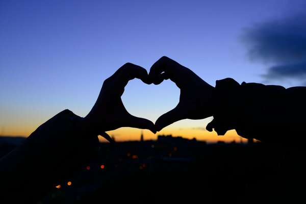 The girl shows a heart from both hands