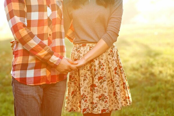 A couple in love holding hands against the background of nature