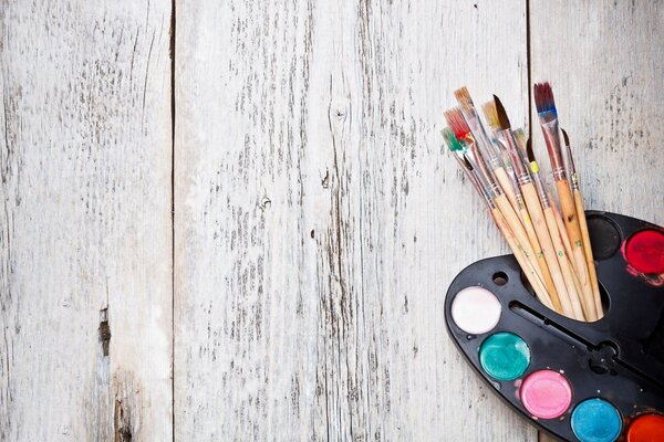 Palette with paints and brushes. Artist