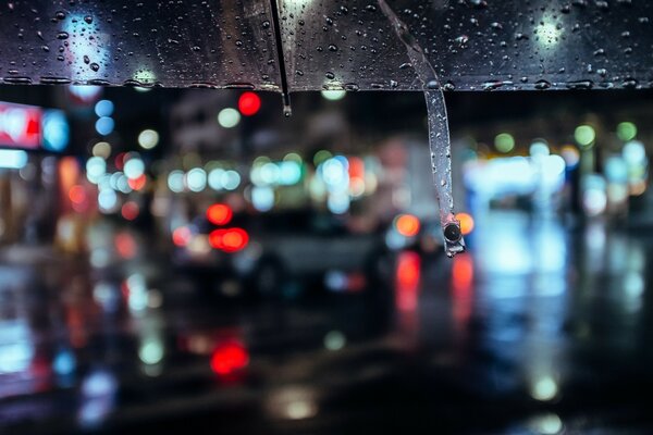 Nachts im Regen unter einem Regenschirm unterwegs