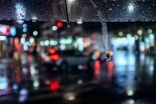 Di notte sotto la pioggia sotto l ombrello sulla strada
