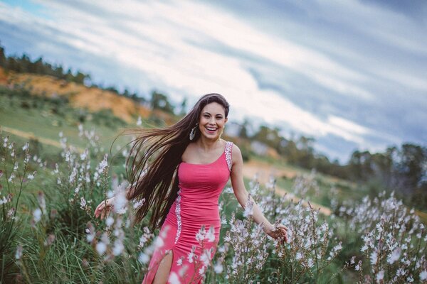 Chica alegre en vestido rosa en el campo