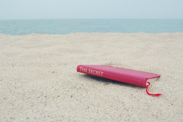 A book on a deserted sandy shore