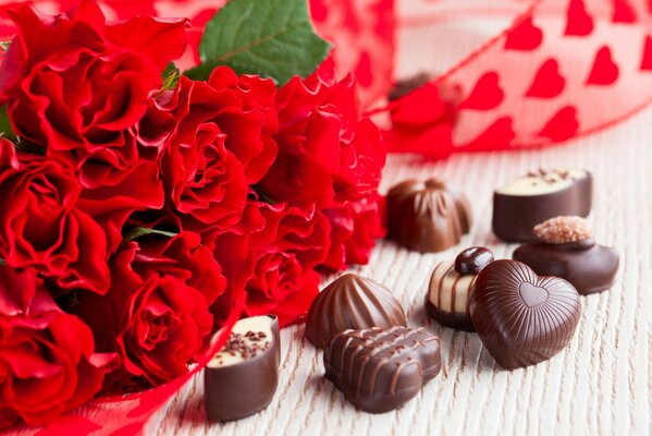 Chocolates with a bouquet of red roses