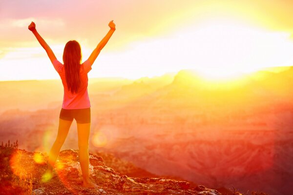 A free athletic girl greets the sun