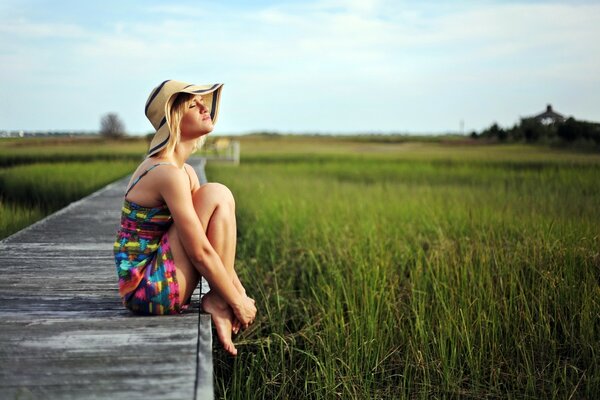 A girl in a hat on a summer meadow