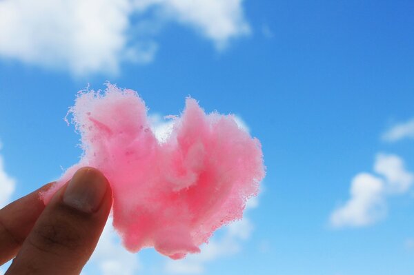 Pink heart on the background of light clouds