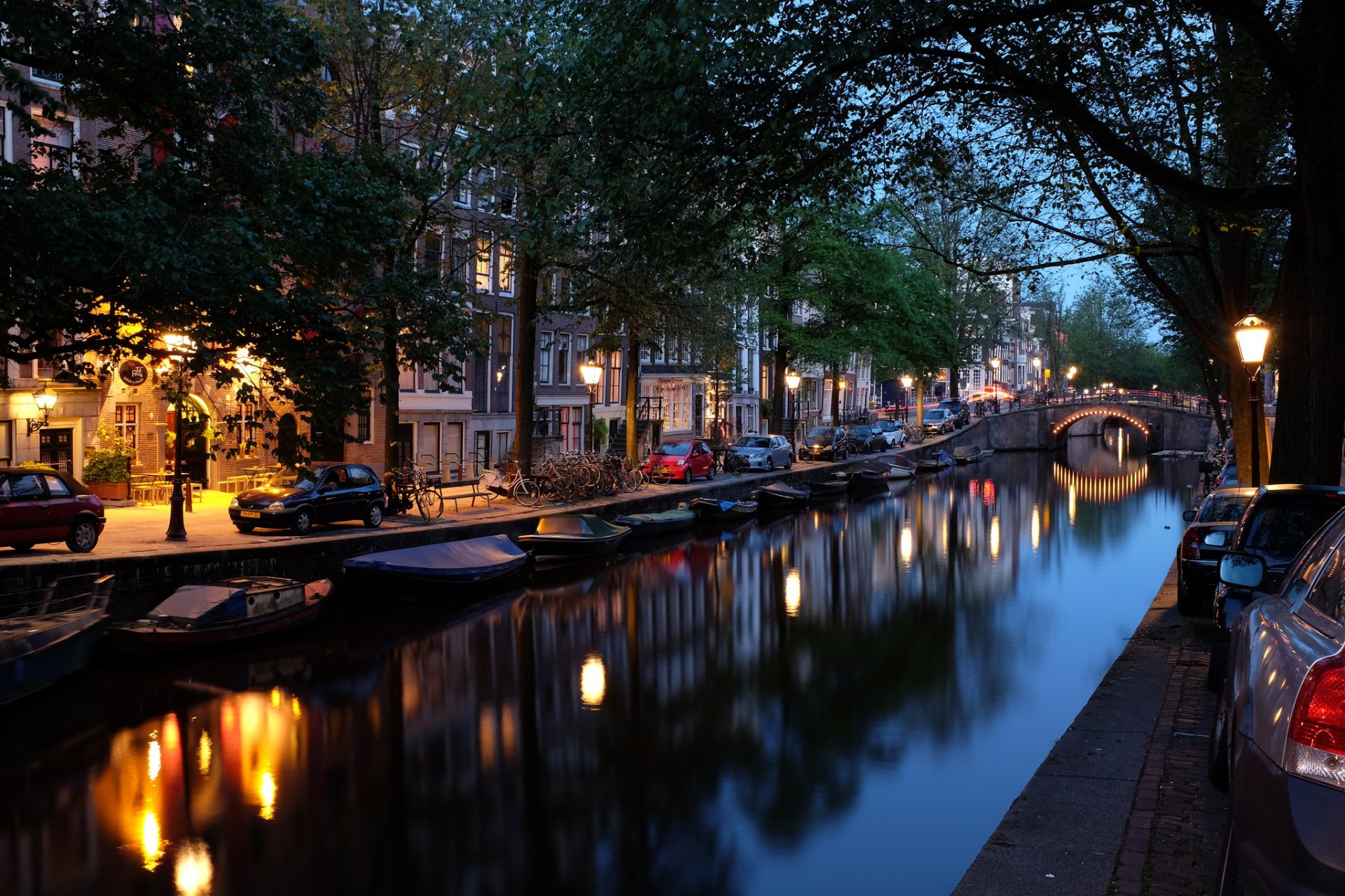 amsterdam pays-bas ville soirée pont canal rivière bateaux voitures maisons lanternes éclairage arbres