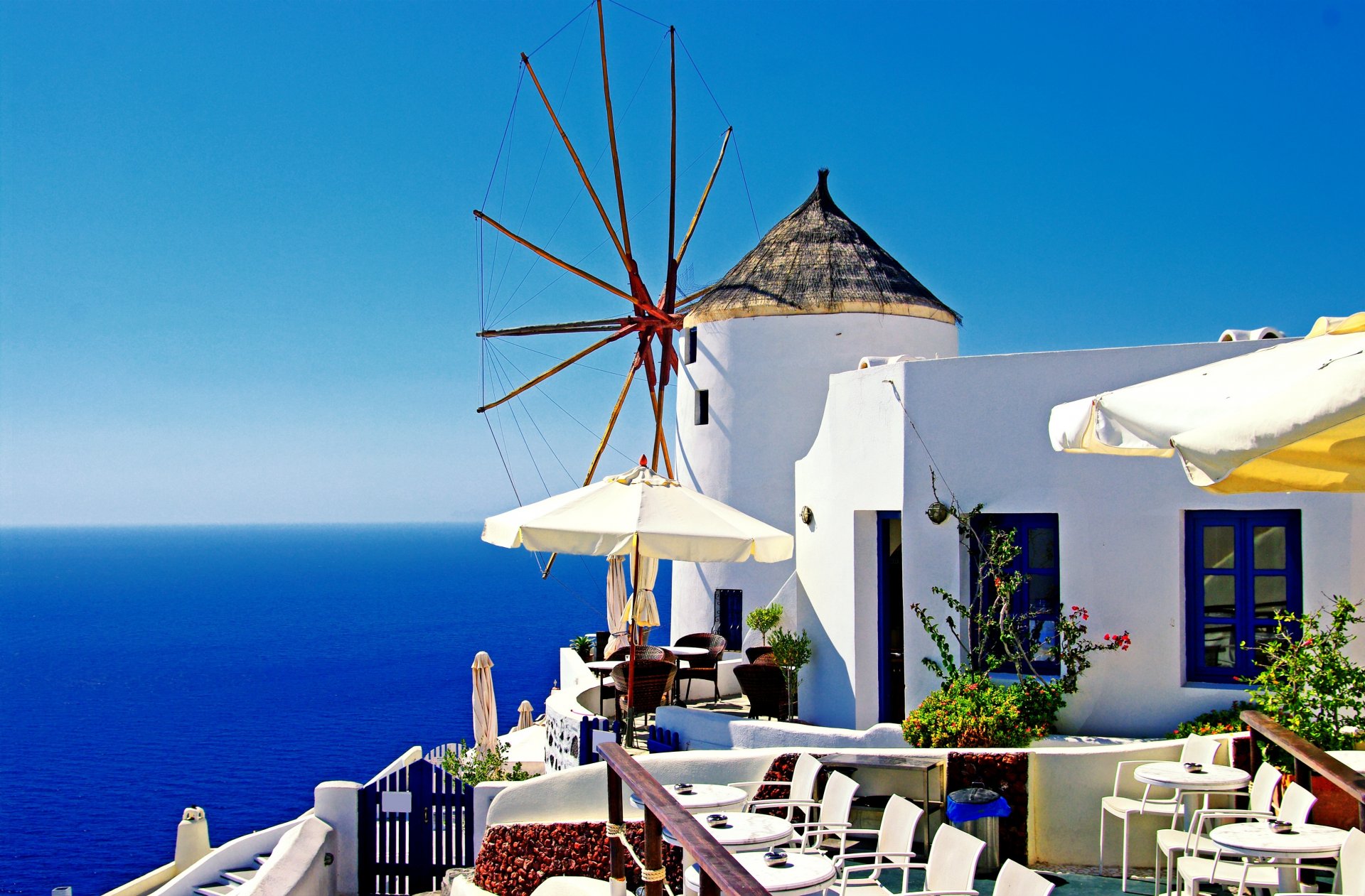 greece oia santorini town mill windmill house tables chairs umbrellas sea nature