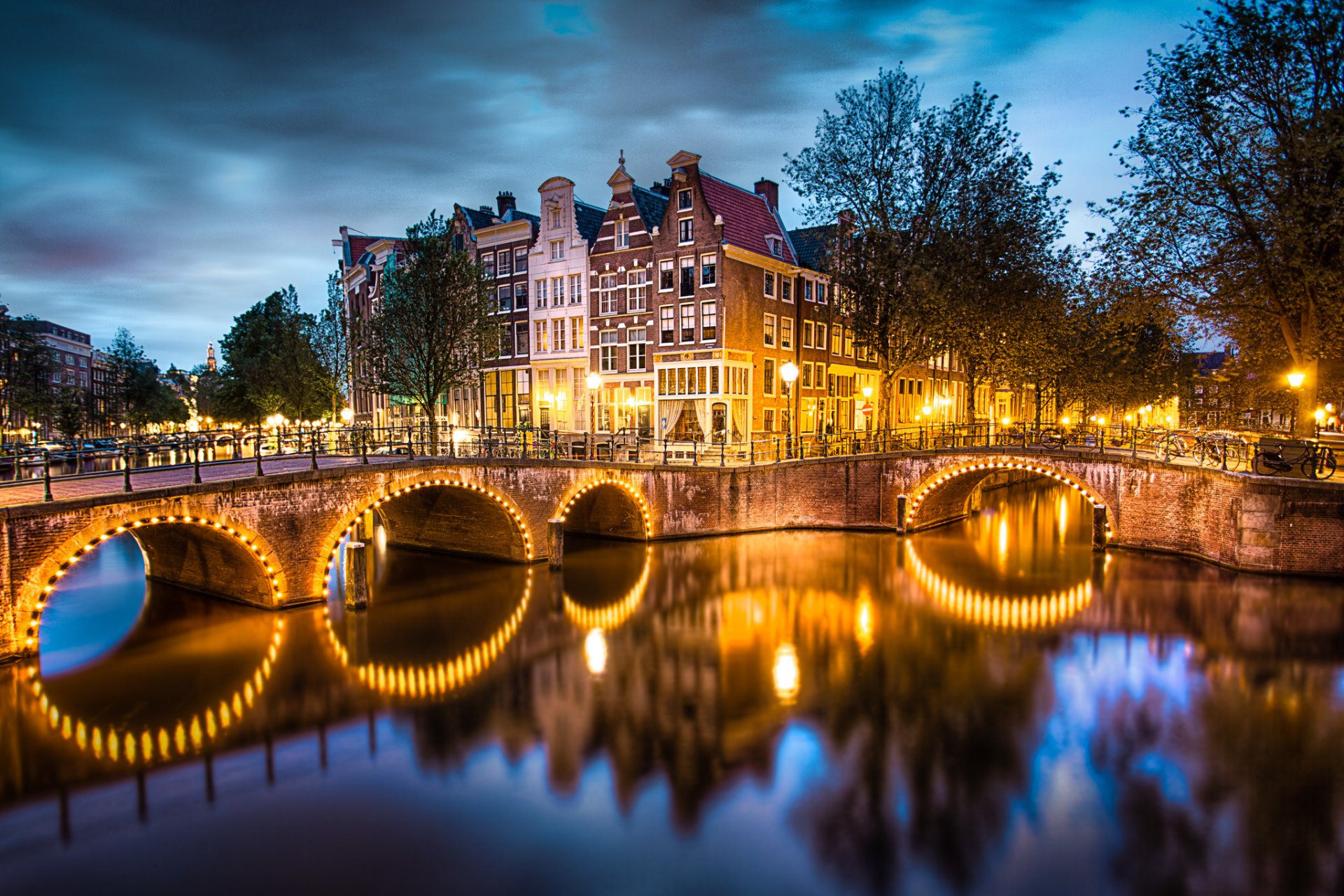 amsterdam países bajos ciudad noche cielo nubes canal puente luces iluminación río agua reflexión casas calles linternas árboles