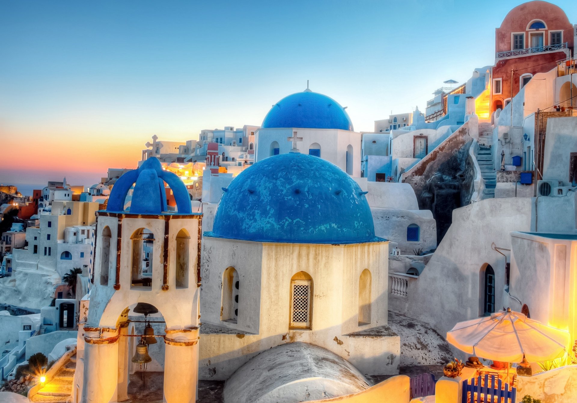 grecia santorini oia sera città illuminazione chiesa cupole case edifici