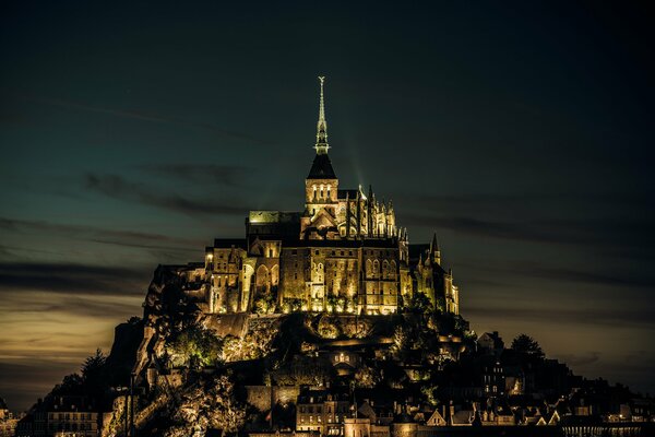 Замок Мон-Сен-Мишель, во Франции на фоне ночного неба