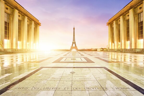 The Eiffel Tower standing in the distance against the background of the evening sky and the granite tile floor