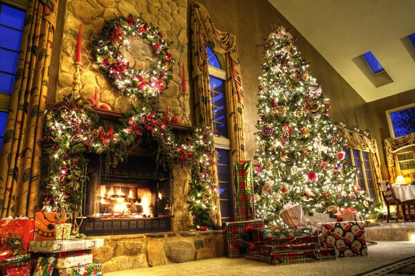 Sapin élégant avec des cadeaux près de la cheminée chaude