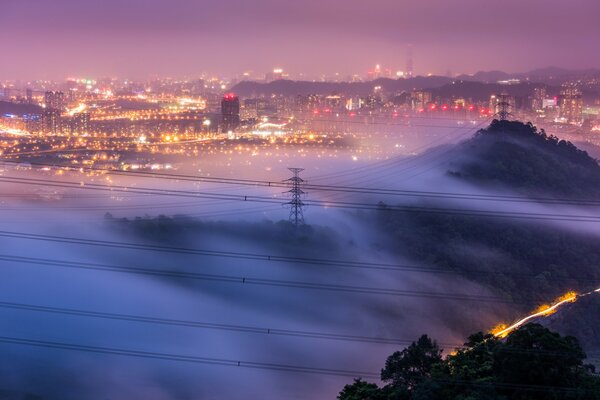 China. Panorama from the height of the city with lights in a lilac fog