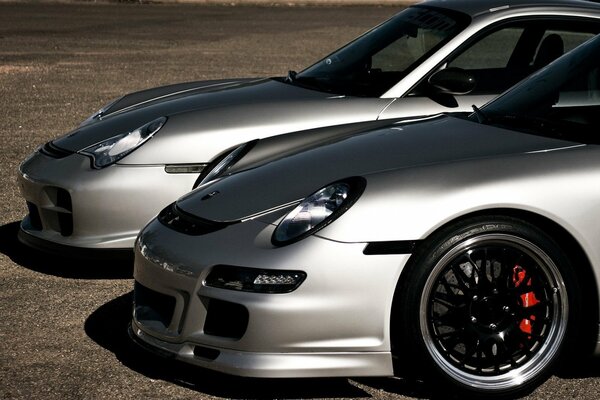 Zwei graue Porsche-Autos stehen nebeneinander